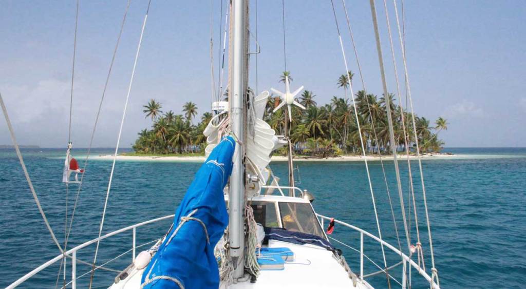 palm tree island with sailing vessel