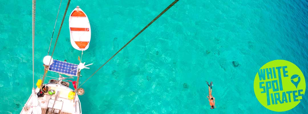 woman snorking next to sailboat