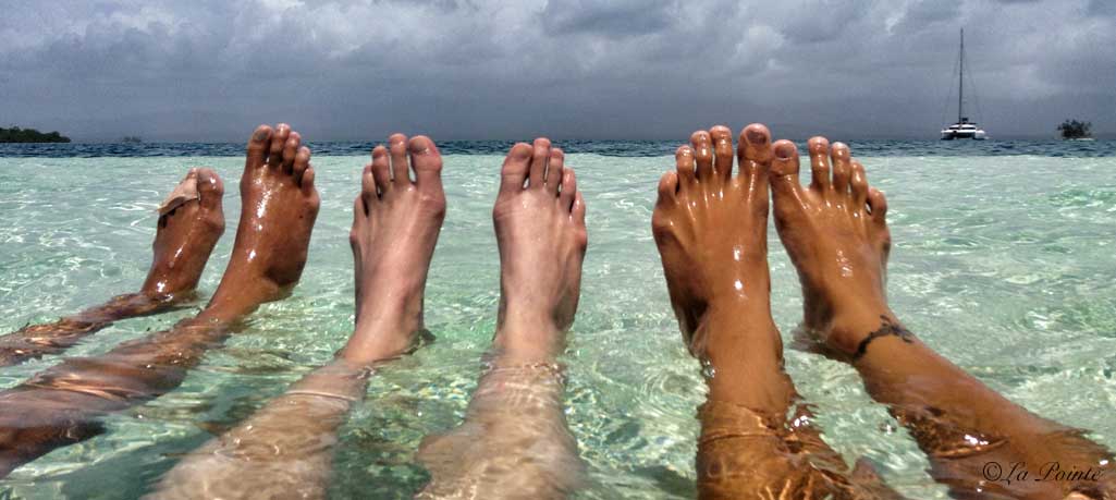 three pair of feet in shallow water in guna Yala
